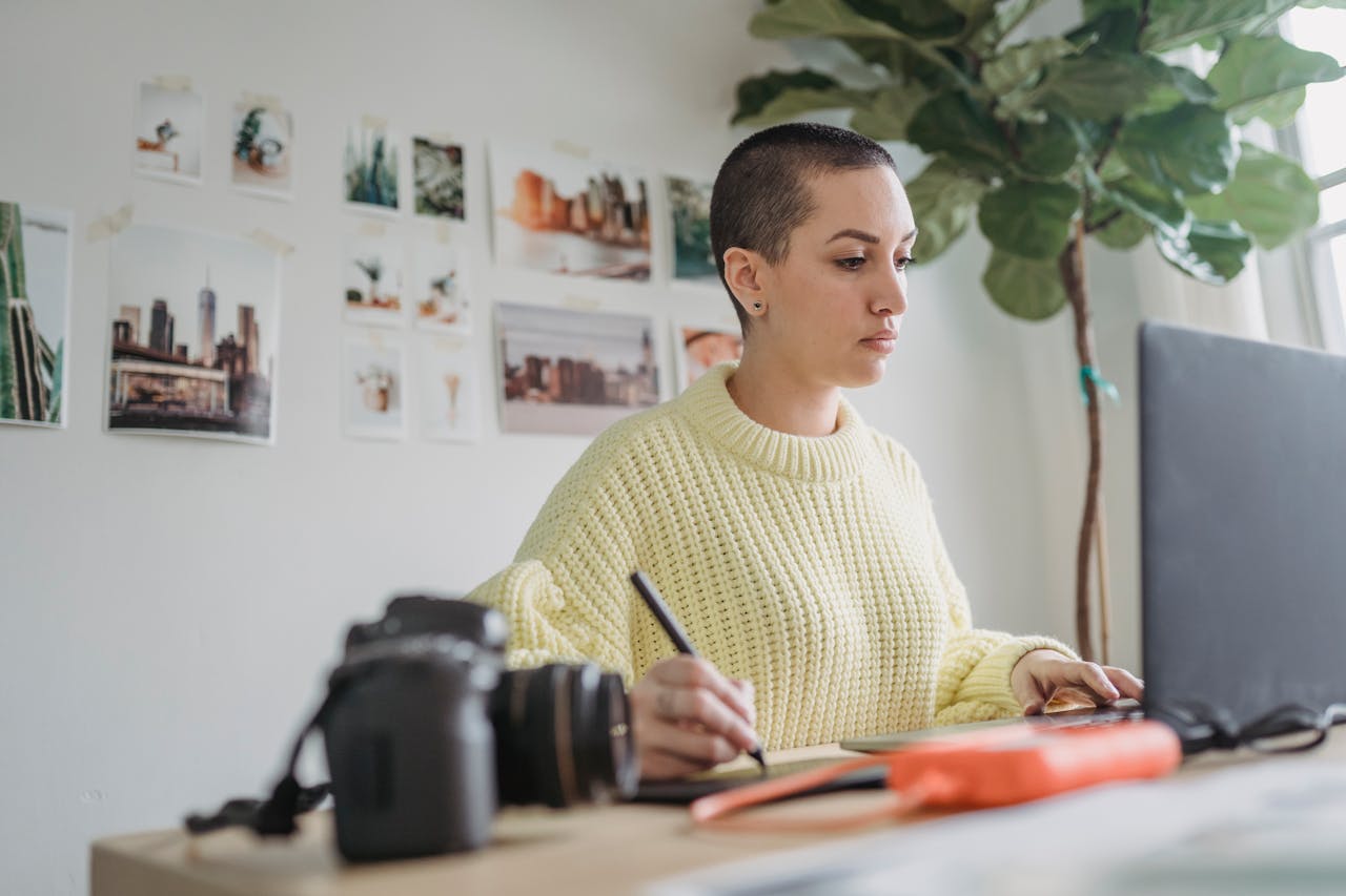Female photographer focusing on digital photo editing at her creative indoor workspace.